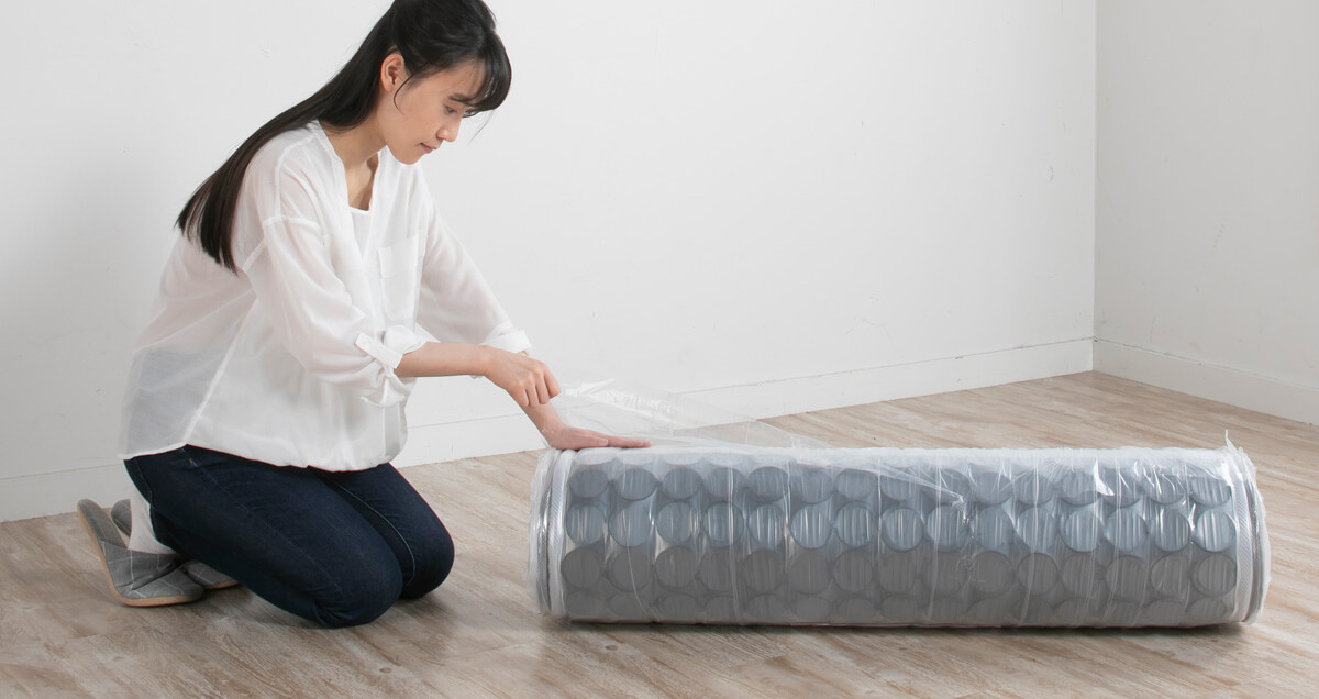 段ボールから圧縮されたマットレスを取り出します