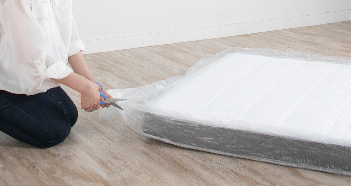 マットレス本体を切らないように注意しながら圧縮シートの端を切ります